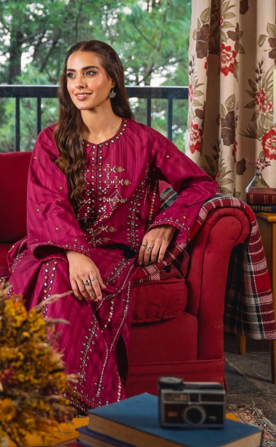 Model in deep magenta wearing stacked silver and gold rings